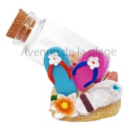 Tongs sur la plage avec bouteille de sable
